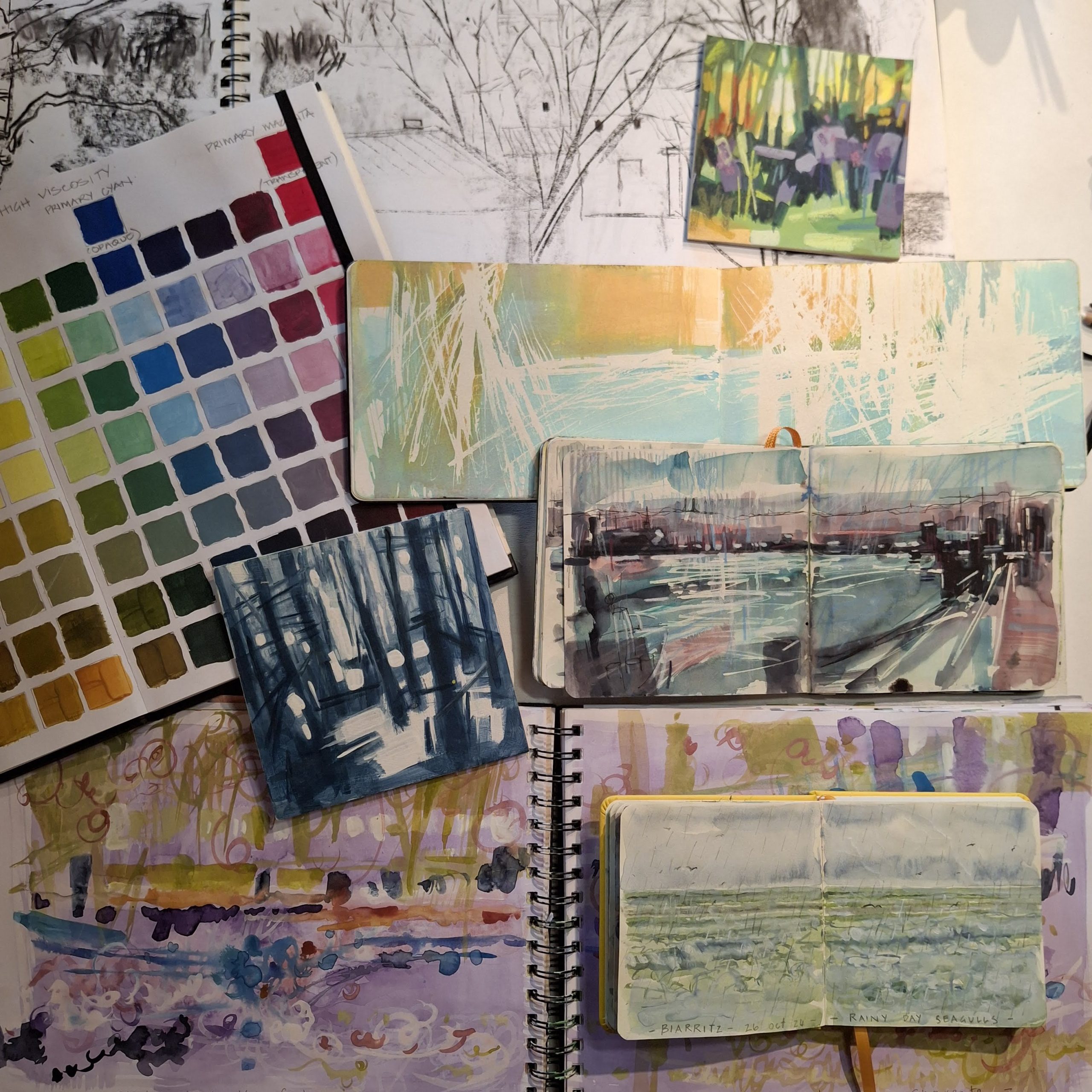 L'image présente une collection de carnets de croquis et de journaux artistiques ouverts, empilés les uns sur les autres. Les styles vont des nuanciers structurés et des dessins à l'encre monochromes aux aquarelles atmosphériques et aux paysages acryliques.